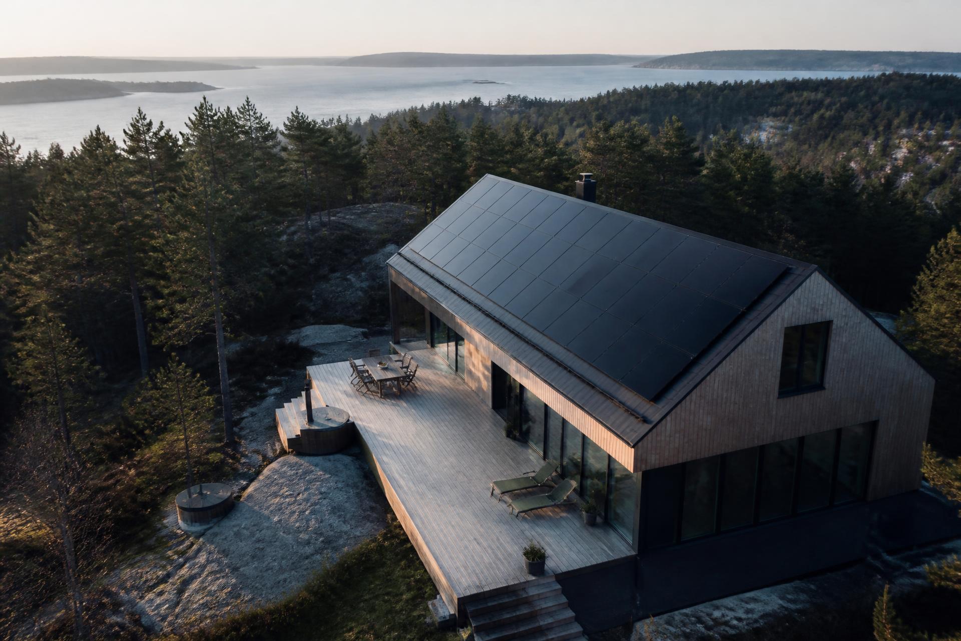 Villa i nordisk skärgårdsmiljö med svarta solcellspaneler på taket